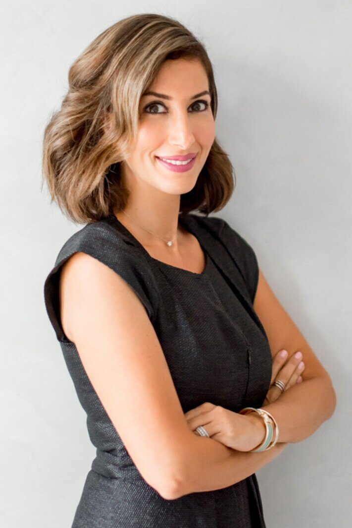 A woman with her arms crossed in front of a wall.